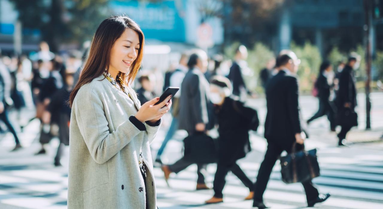 繁华都市里拿着手机的女孩