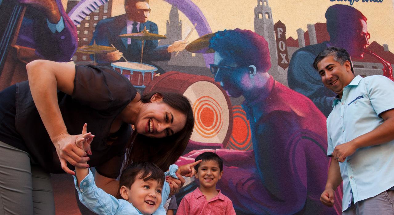 站在为弘扬城市音乐和文化而绘制的壁画前拍照留念