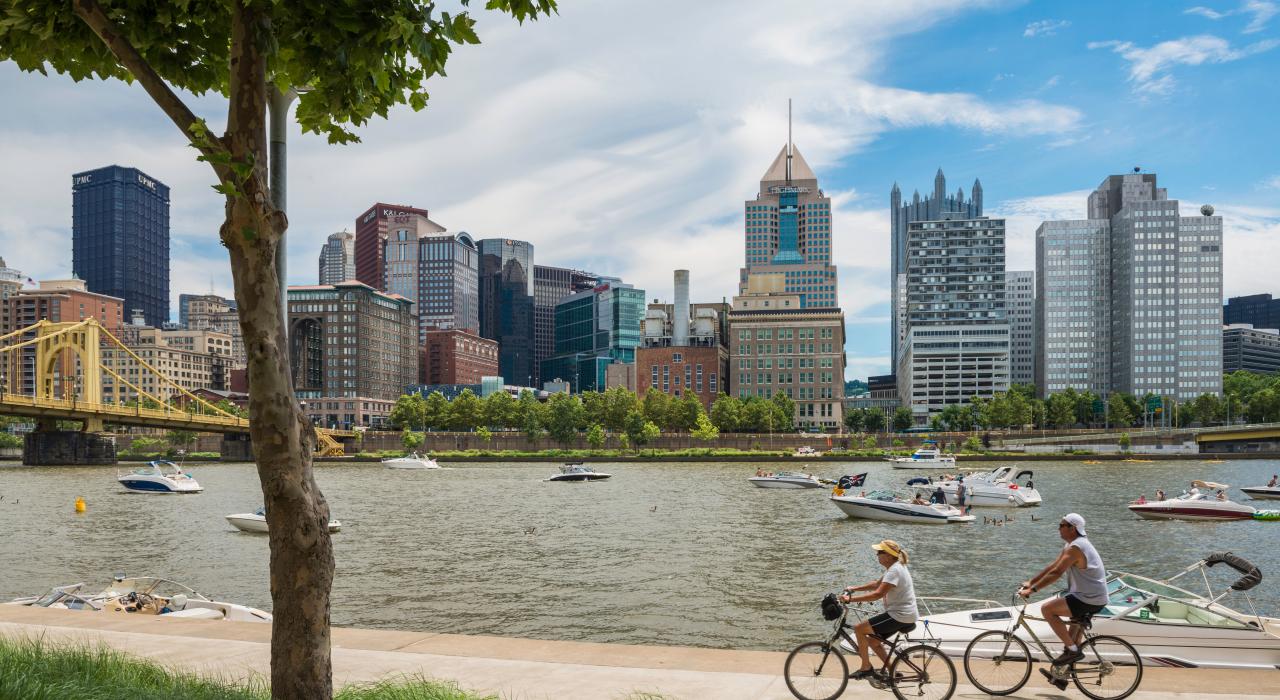 在城市的一条 39 公里的河滨小径上沿着阿勒格尼河骑行 在城市的一条 39 公里的河滨小径上沿着阿勒格尼河骑行