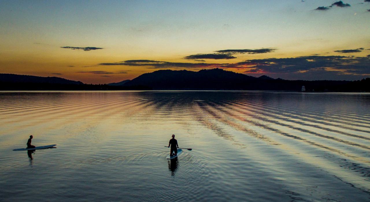 黄昏时分在湖面上划起浮板独木舟