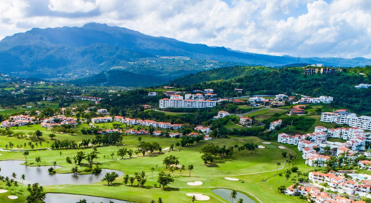 在鸟瞰波多黎各格兰德河畔的 Rio Mar Country Club 俱乐部鸟瞰高尔夫球场和迷人山景