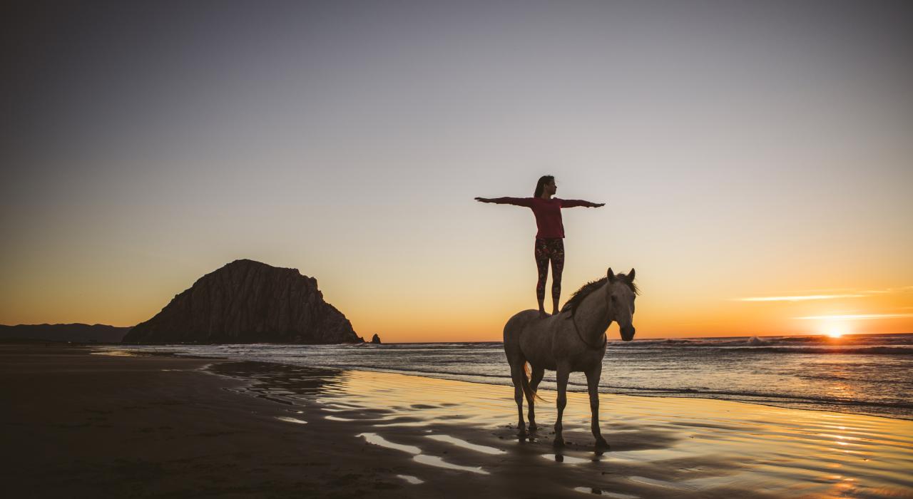 在加利福尼亚州圣路易斯-奥比斯波的莫洛岩石美景映衬下体验马上瑜伽