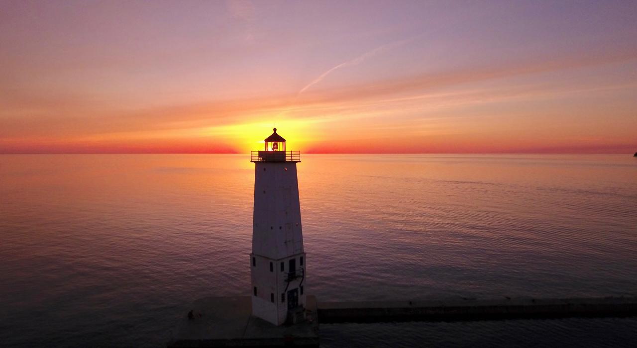 夕阳余晖洒落在法兰克福灯塔后面的密歇根湖上