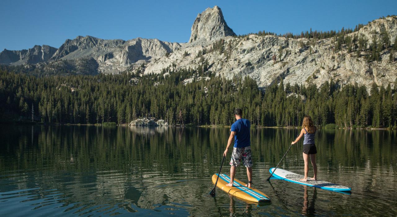 在加利福尼亚州马麦斯湖附近的乔治湖上体验站立桨板冲浪