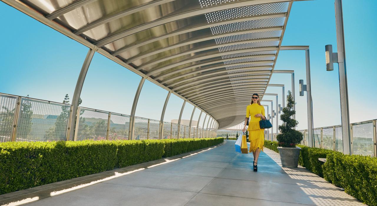 手拿购物袋穿过南海岸广场的联合桥 手拿购物袋穿过南海岸广场的联合桥