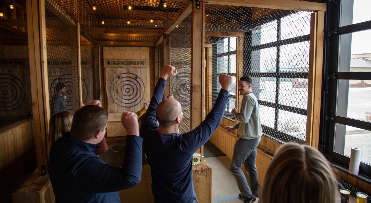 在当地小酒馆 Laughing Sun Brewing Co. 享受投掷斧头游戏的乐趣