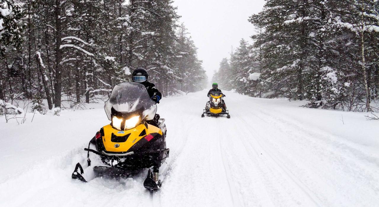 雪地摩托车手在白雪覆盖的雪道上驰骋