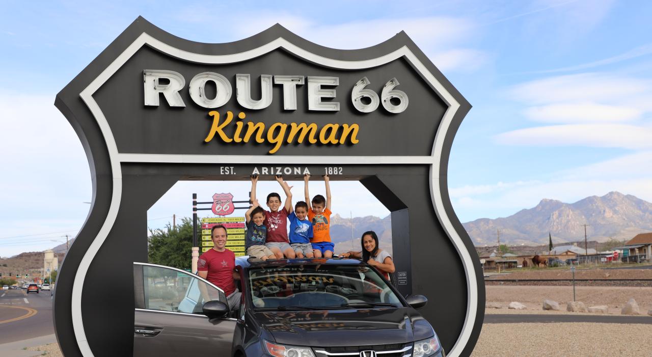 一家人在金曼游客中心的 Route 66 Drive-Thru Shield 景点前合影留念 一家人在金曼游客中心的 Route 66 Drive-Thru Shield 景点前合影留念