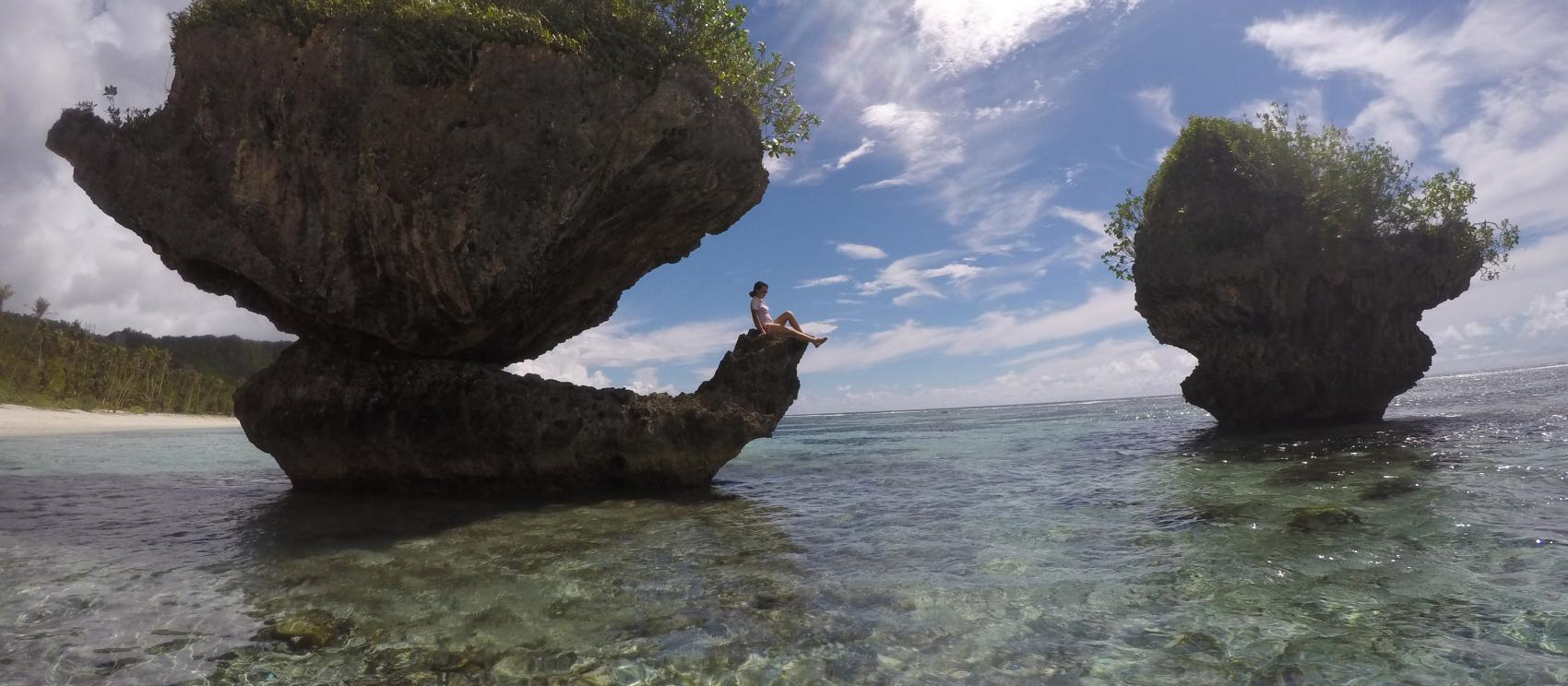在蘑菇岩上休息的女游客 在蘑菇岩上休息的女游客
