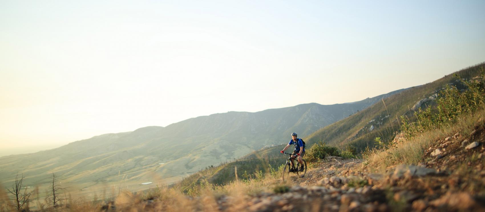 在景色优美的崎岖地形上骑山地自行车